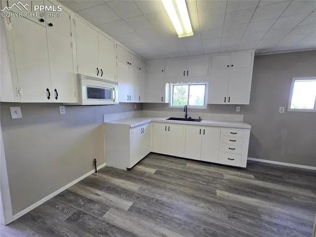 a large kitchen with a lot of counter space and wooden floor