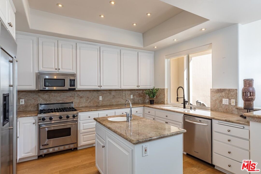 6438 Lunita Road Malibu, CA 90265 - Photo 7 of 34 a kitchen with a sink stove and cabinets