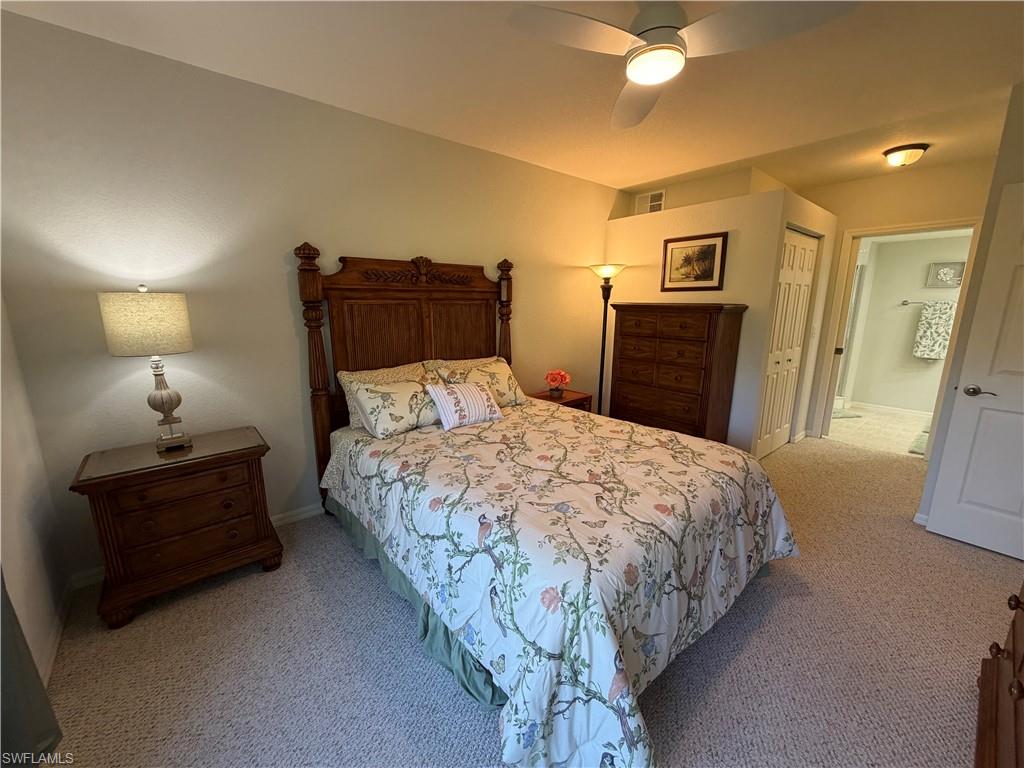 23810 Marbella Bay Road, Unit 102 Estero, FL 34135 - Photo 19 of 26 a bedroom with a bed and a chandelier