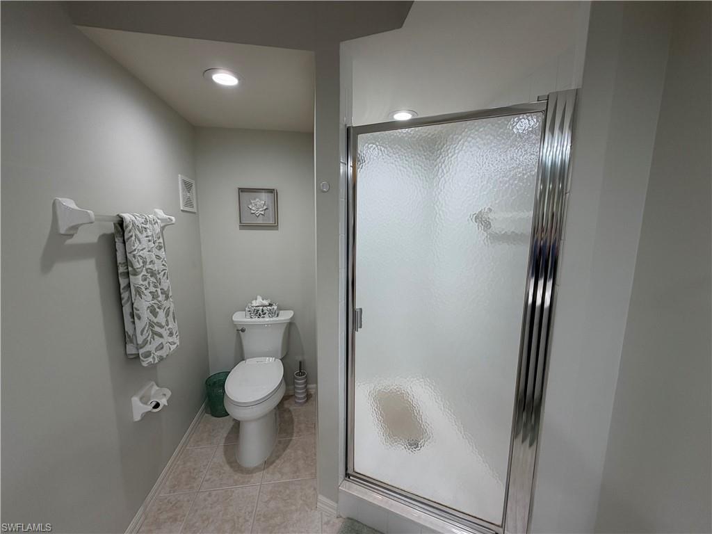 23810 Marbella Bay Road, Unit 102 Estero, FL 34135 - Photo 20 of 26 a bathroom with a toilet and a glass door