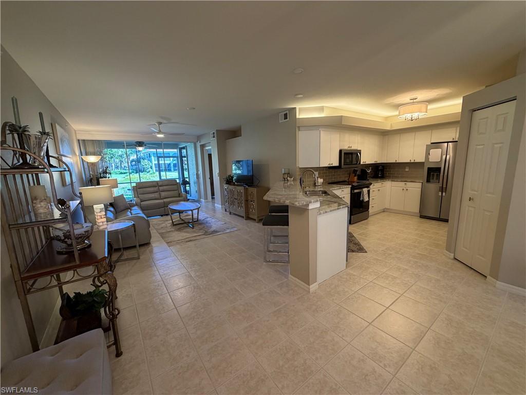 23810 Marbella Bay Road, Unit 102 Estero, FL 34135 - Photo 2 of 26 a kitchen with a refrigerator and a stove top oven