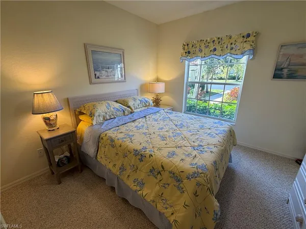 a bed sitting in a bedroom next to a window