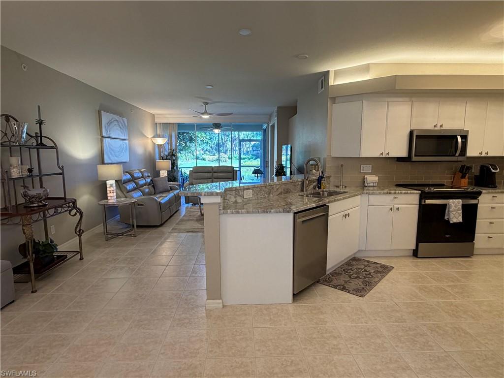 23810 Marbella Bay Road, Unit 102 Estero, FL 34135 - Photo 3 of 26 a kitchen with a sink cabinets and window