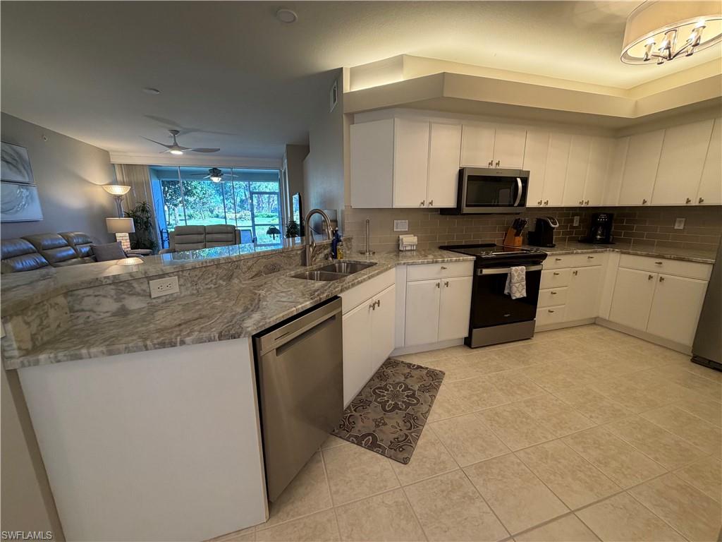 23810 Marbella Bay Road, Unit 102 Estero, FL 34135 - Photo 5 of 26 a kitchen with stainless steel appliances granite countertop a sink stove and refrigerator