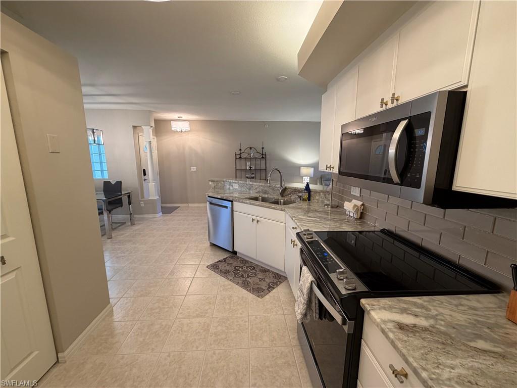 23810 Marbella Bay Road, Unit 102 Estero, FL 34135 - Photo 7 of 26 a kitchen with a sink stove and cabinets
