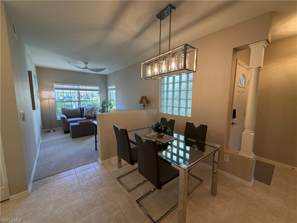 23810 Marbella Bay Road, Unit 102 Estero, FL 34135 - Photo 8 of 26 a living room with furniture and a chandelier