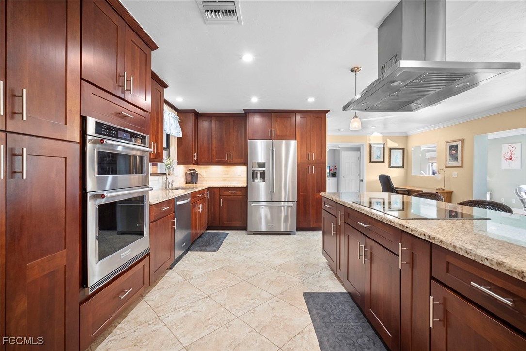 5688 Arvine Circle Fort Myers, FL 33919 - Photo 4 of 39 a kitchen with stainless steel appliances granite countertop a refrigerator a stove and a sink with wooden cabinets