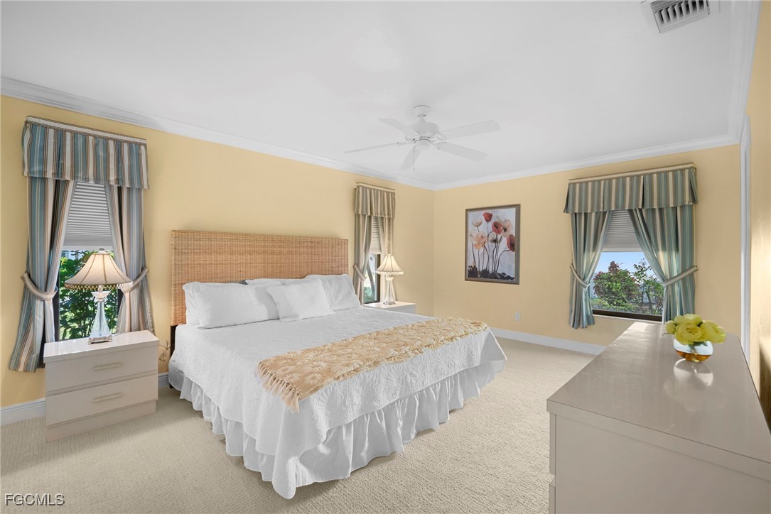5688 Arvine Circle Fort Myers, FL 33919 - Photo 10 of 39 a bedroom with a large bed and a chandelier