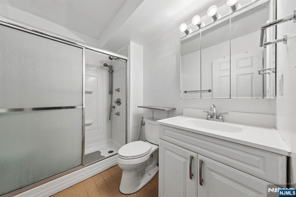 326 Prospect Avenue, Unit 10H Hackensack, NJ 07601 - Photo 13 of 31 a bathroom with a sink a toilet and shower