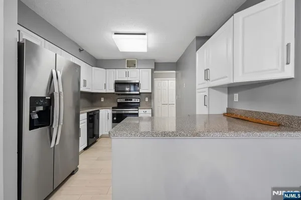 a kitchen with stainless steel appliances granite countertop a refrigerator a stove a sink and a granite counter tops