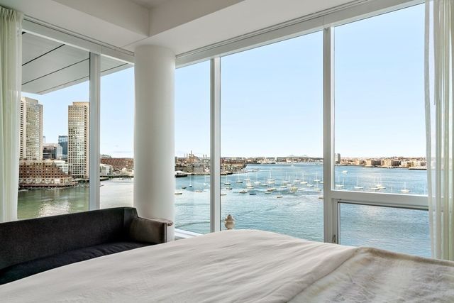 a bedroom with a large window and a balcony