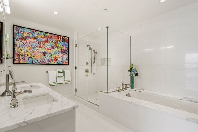 a bathroom with a tub a sink and mirror