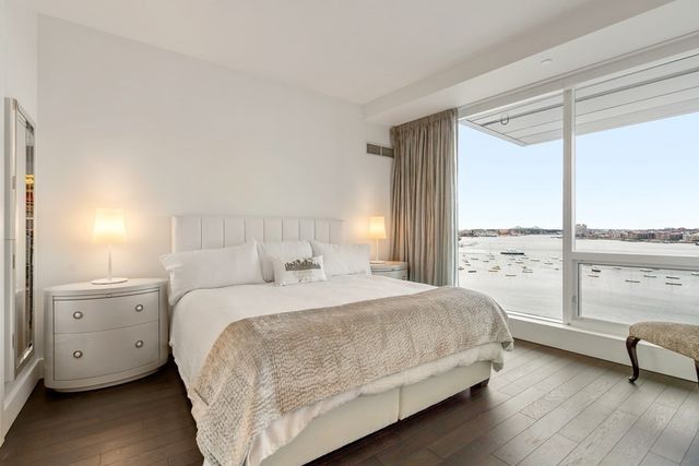 a bedroom with a bed and a large window with balcony view