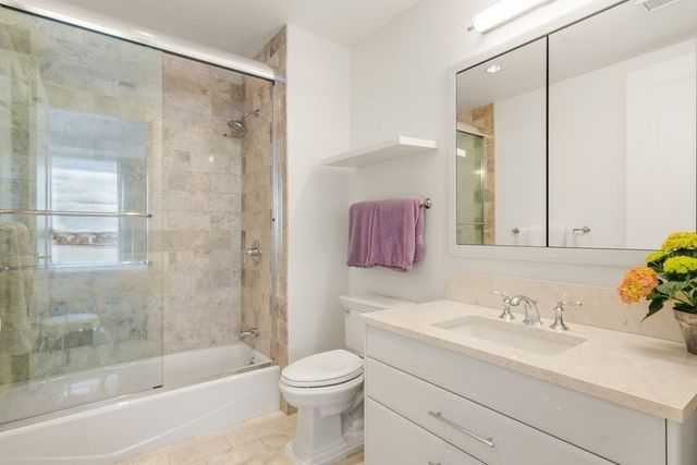 a bathroom with a granite countertop sink a toilet and shower