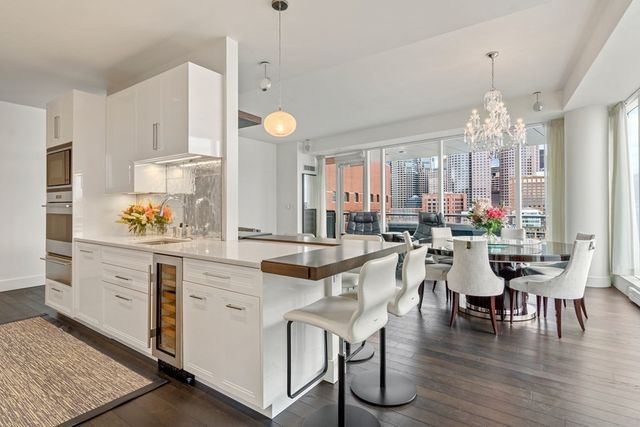 a kitchen with stainless steel appliances kitchen island granite countertop a table and chairs in it