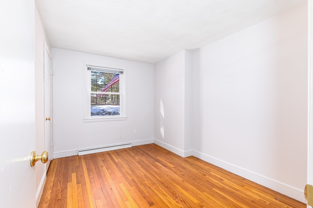 24 Pomeroy Road, Unit 24 North Reading, MA 01864 - Photo 12 of 21 an empty room with wooden floor and windows