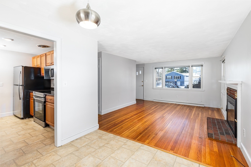24 Pomeroy Road, Unit 24 North Reading, MA 01864 - Photo 4 of 21 a view of an empty room with a window and wooden floor