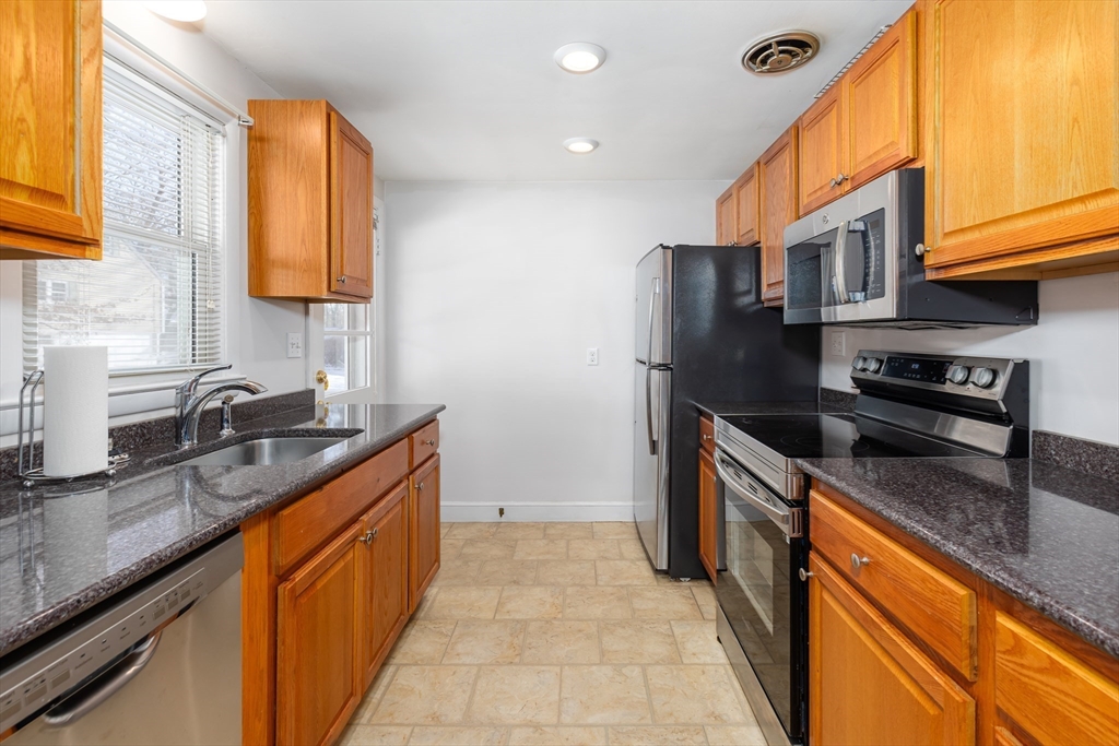 24 Pomeroy Road, Unit 24 North Reading, MA 01864 - Photo 5 of 21 a kitchen with stainless steel appliances granite countertop a sink and a stove