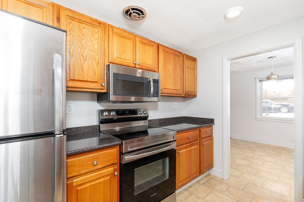 24 Pomeroy Road, Unit 24 North Reading, MA 01864 - Photo 6 of 21 a kitchen with stainless steel appliances granite countertop a stove a sink and a microwave