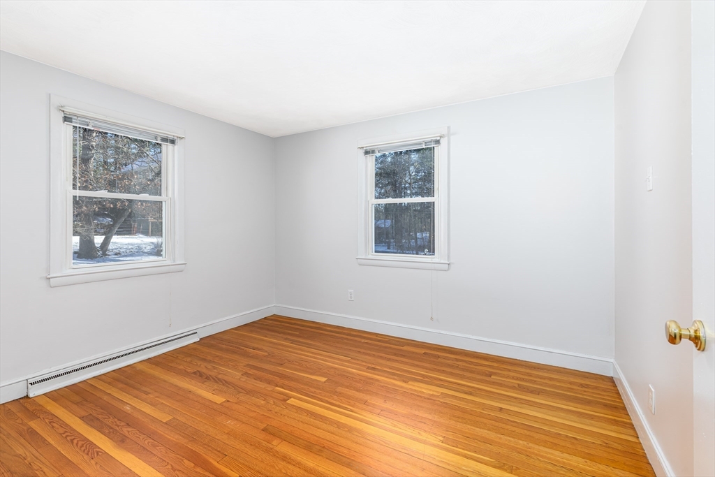 24 Pomeroy Road, Unit 24 North Reading, MA 01864 - Photo 10 of 21 a view of an empty room with wooden floor and a window