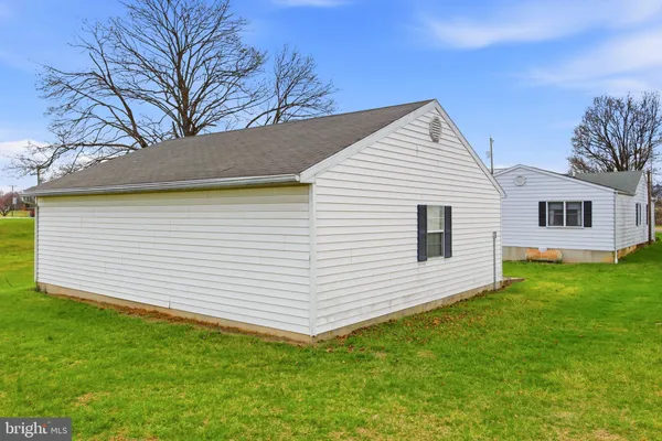 a view of a white house next to a yard