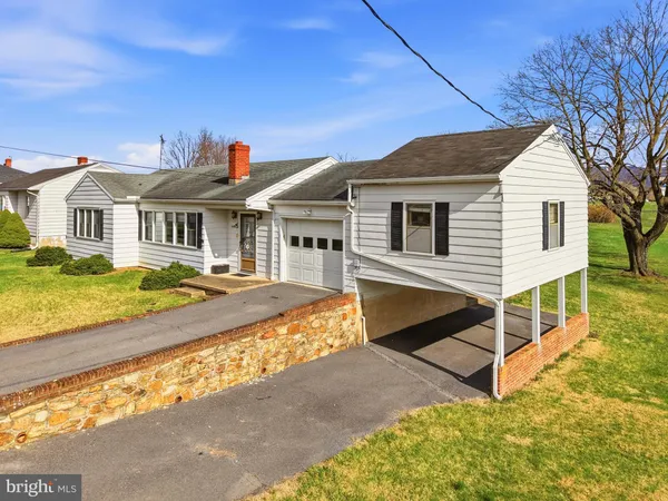 a view of a white house with large windows and a yard