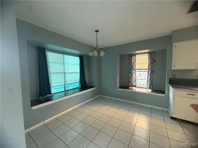 a view of an empty room with a window and fire place