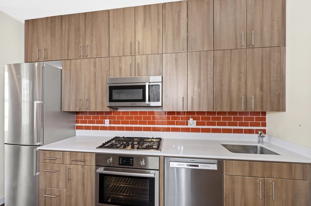 45 1st Avenue, Unit 406 Boston, MA 02129 - Photo 2 of 13 a kitchen with stainless steel appliances a stove a microwave and a refrigerator