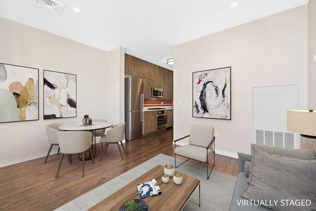 45 1st Avenue, Unit 406 Boston, MA 02129 - Photo 5 of 13 a living room with furniture and a dining table with wooden floor