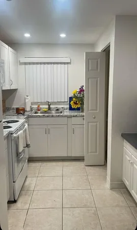 a kitchen with a stove sink and cabinets
