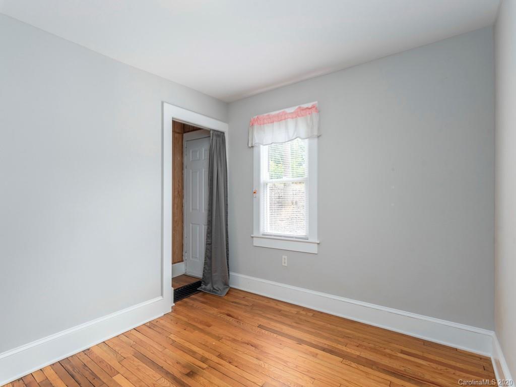793 Morning Star Road Canton, NC 28716 - Photo 14 of 24 an empty room with wooden floor and windows