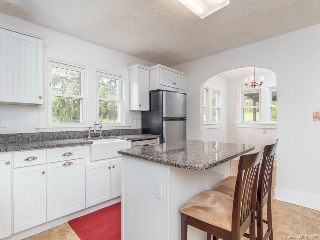 793 Morning Star Road Canton, NC 28716 - Photo 7 of 24 a kitchen with kitchen island granite countertop a sink cabinets and window