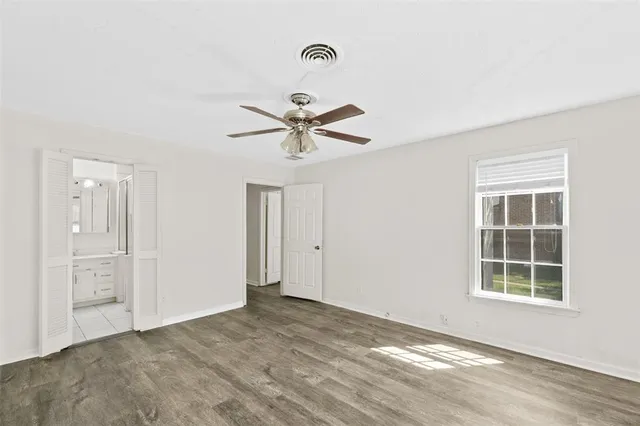 an empty room with closet and windows