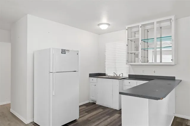 a kitchen with granite countertop a sink and a refrigerator