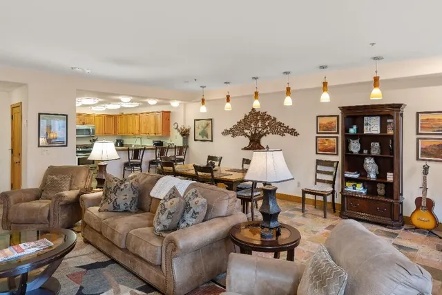 a living room with furniture kitchen view and a large window