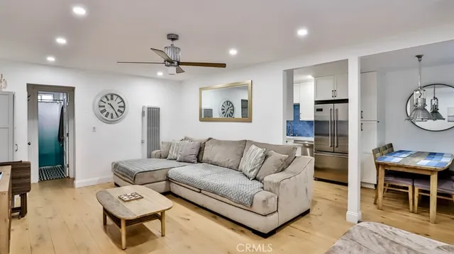 a living room with furniture a clock on wall and a table