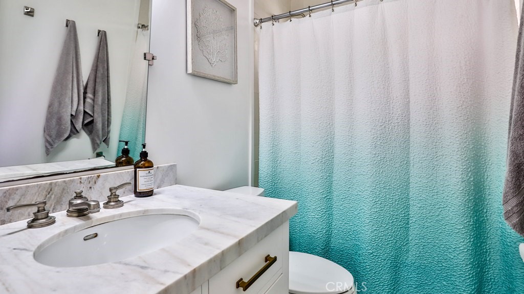 218 16th Street, Unit B Huntington Beach, CA 92648 - Photo 14 of 14 a bathroom with a sink toilet and mirror