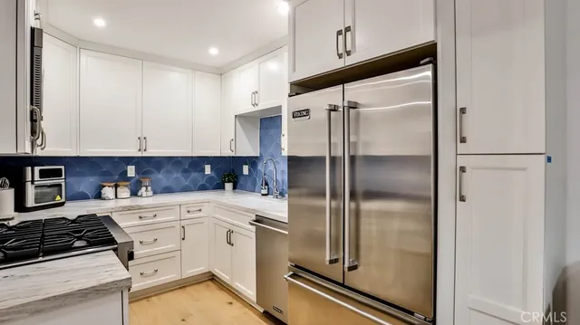 a kitchen with a refrigerator a sink and cabinets