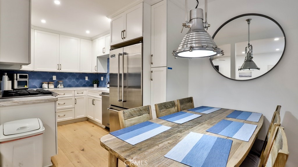 218 16th Street, Unit B Huntington Beach, CA 92648 - Photo 6 of 14 a kitchen that has a lot of white cabinets and chandelier
