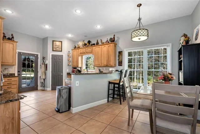 a living room with furniture a large window with kitchen view