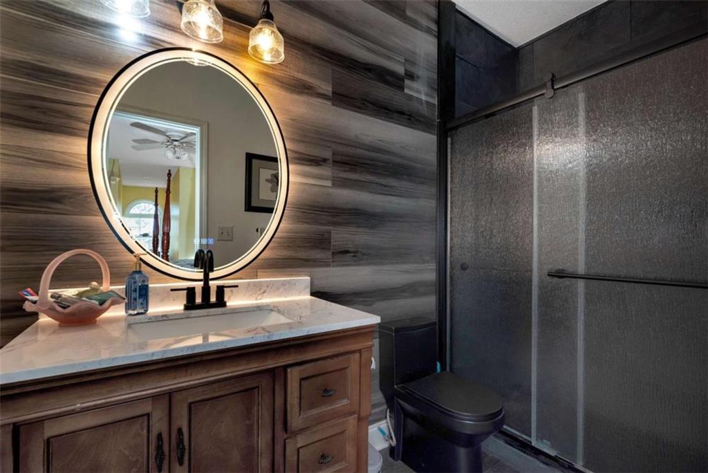 51 Howiington Road Jefferson, GA 30549 - Photo 45 of 81 a bathroom with a granite countertop toilet a sink and a mirror