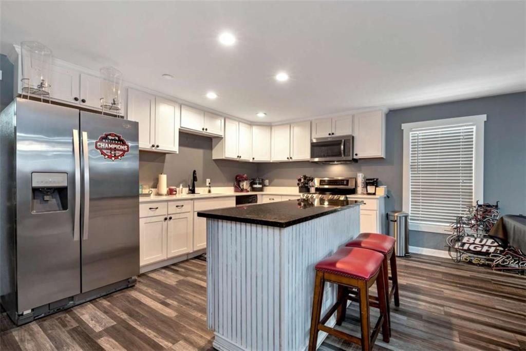 51 Howiington Road Jefferson, GA 30549 - Photo 49 of 81 a kitchen with granite countertop a refrigerator a sink dishwasher a stove and a refrigerator with wooden floor
