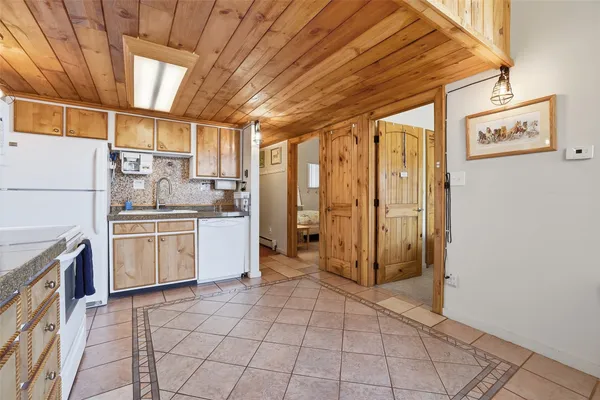 a kitchen with a refrigerator a stove top oven and cabinets