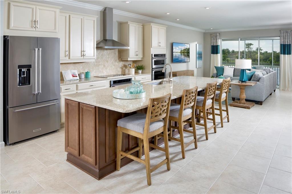 4677 Arboretum Circle, Unit 202 Naples, FL 34112 - Photo 7 of 15 a kitchen with stainless steel appliances granite countertop a table and chairs