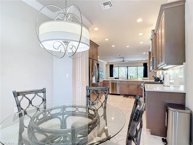 a dining room filled a chandelier with wooden floor