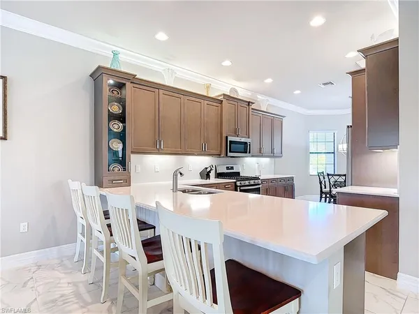 a kitchen with kitchen island a stove a table and chairs in it