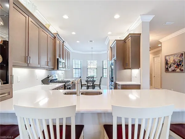 a kitchen with stainless steel appliances granite countertop a sink a stove and a refrigerator