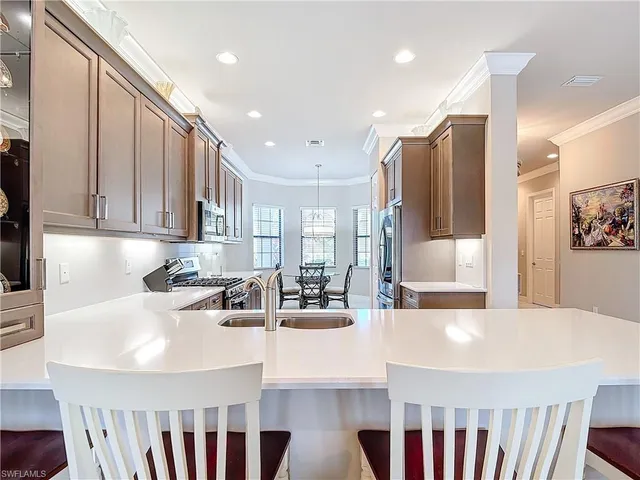 a kitchen with stainless steel appliances granite countertop a sink a stove and a refrigerator