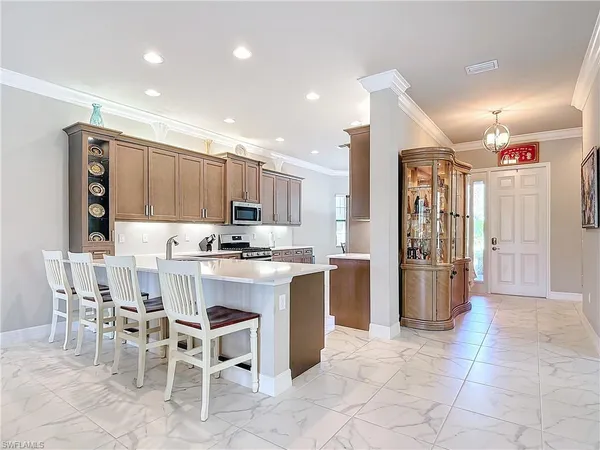 a kitchen with a sink chairs and refrigerator