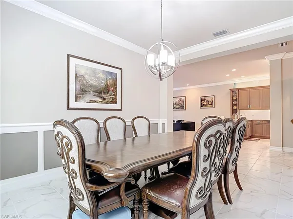 a view of a dining room and livingroom view with furniture a chandelier and wooden floor